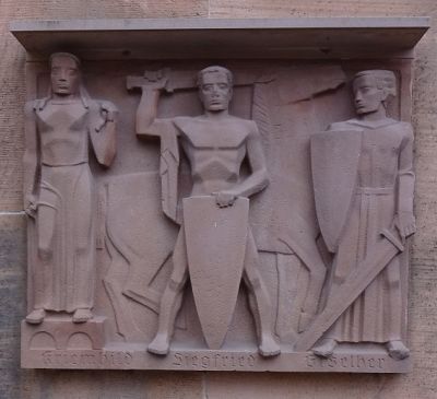 Tre av Nibelungensångens figurer - Krimhild, Siegfried och Giselher – på kyrkofasaden.